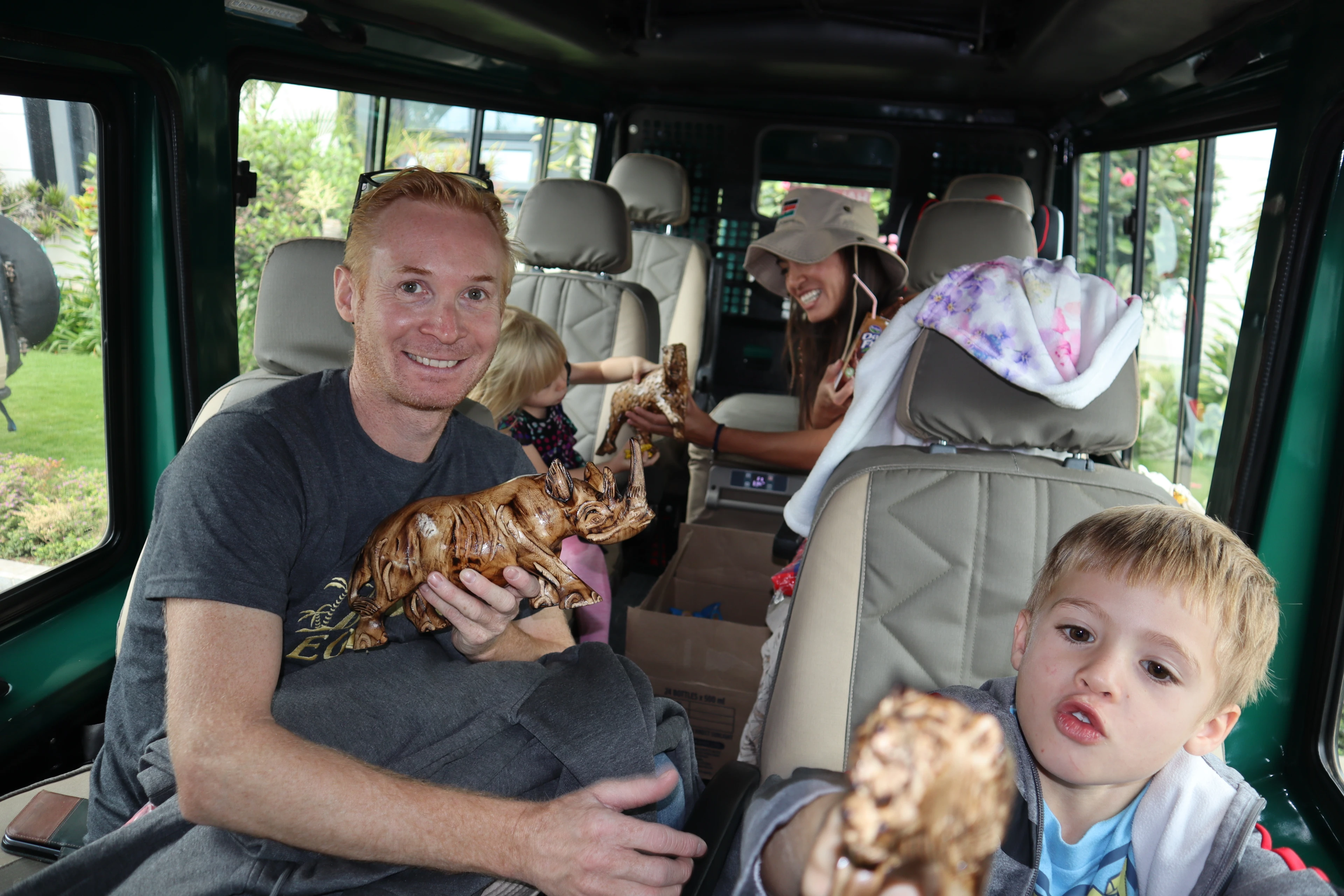 A family receiving welcome gifts inside a safari Land Cruiser before starting their Kenya safari with Norine Forbes Safaris.